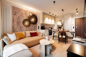 a living room with a couch and a kitchen at Scala Apartments by Blue Mandarin in Gdańsk