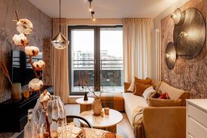 a living room with a couch and a large window at Scala Apartments by Blue Mandarin in Gdańsk