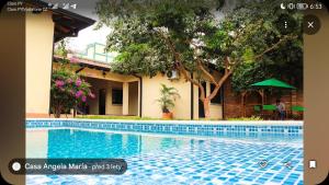 a swimming pool in front of a building at Casa Angela María in Caacupé