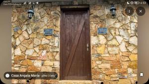 a wooden door on a stone wall with lights at Casa Angela María in Caacupé