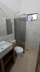 a bathroom with a toilet and a sink and a mirror at Casa Angela María in Caacupé
