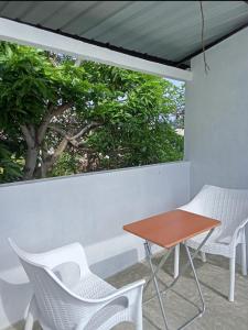 une table et des chaises sur un balcon avec un arbre dans l'établissement Rian Rest, à Gangodawila