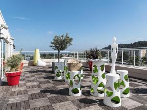 イエールにあるIbis Styles Hyères Rooftop & Spaの白と緑の花瓶と植物が飾られたバルコニー