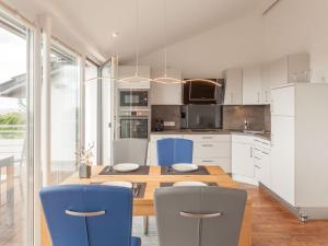 a kitchen with a wooden table and blue chairs at One-bedroom apartment in Sassnitz