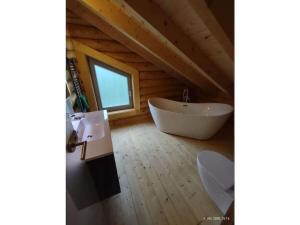 une salle de bain avec baignoire et fenêtre dans un grenier dans l'établissement Holiday home in Rieden with swimming pool, à Rieden 12 autres photos