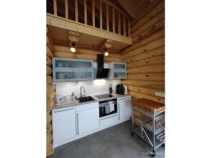 une cuisine avec des armoires blanches et des murs en bois dans l'établissement Holiday home in Rieden with swimming pool, à Rieden