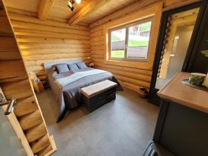 une chambre avec un lit dans une cabane en rondins dans l'établissement Log cabin Waldsee 8, à Rieden