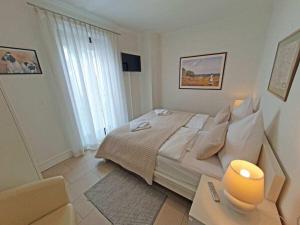 a white bedroom with a bed and a table at One-bedroom apartment in Sassnitz
