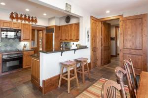 ジャクソンにあるModern Comfort Near Trails and Town in Jacksonのキッチン(木製キャビネット付)、バー(スツール付)