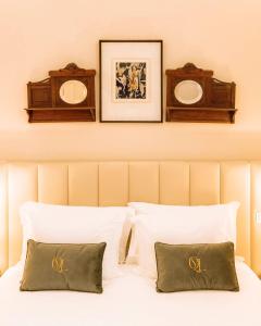a bedroom with a bed with two pictures on the wall at Quinta das Luzes by Casa dos Sequeiras in Vila Nova de Gaia