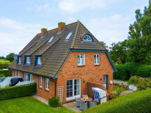 ein Backsteinhaus mit einem Gameradach in der Unterkunft Holiday apartment with 2 bedrooms in Oldsum