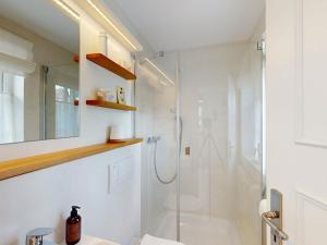 ein weißes Badezimmer mit Dusche und Waschbecken in der Unterkunft Holiday apartment with 2 bedrooms in Oldsum