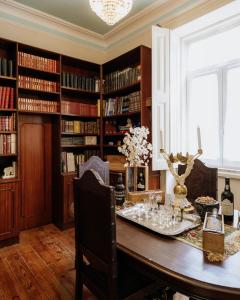 a dining room with a table and bookshelves at Quinta das Luzes by Casa dos Sequeiras in Vila Nova de Gaia