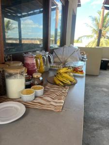 a table with plates of food and bananas on it at Vila Dádiva Jeri in Jericoacoara