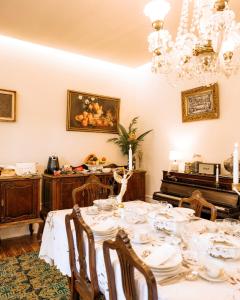 a dining room with a table and a piano at Quinta das Luzes by Casa dos Sequeiras in Vila Nova de Gaia
