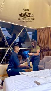 ワディ・ラムにあるRUM DESERT BREEZE lUXURY CAMPのベッドのある部屋に立っている男性と女性 +37枚の写真