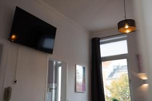a flat screen tv on a wall next to a window at Apartment Lebenslang - Nähe Weserstadion & Viertel in Bremen