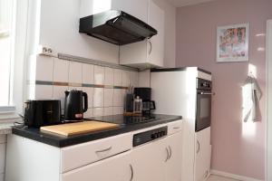 a kitchen with white cabinets and a white refrigerator at Apartment Lebenslang - Nähe Weserstadion & Viertel in Bremen