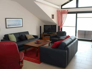 a living room with two couches and a tv at One-bedroom apartment in Sassnitz