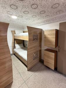 a room with two bunk beds and a ceiling at Soul Surf House in Agadir