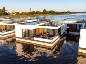 une maison sur un bateau dans l'eau dans l'établissement Bernstein Resort, à Dorf Körkwitz