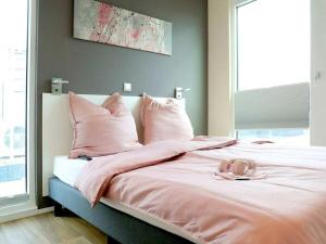 - un lit avec des oreillers roses et une couverture rose dans l'établissement Bernstein Resort, à Dorf Körkwitz