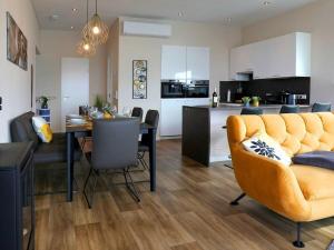 un salon et une cuisine avec un canapé jaune et une table dans l'établissement Bernstein Resort, à Dorf Körkwitz