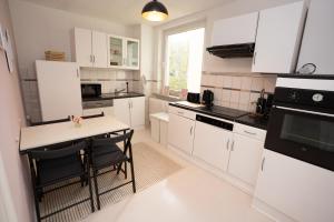 a kitchen with white cabinets and a table with chairs at Apartment Lebenslang - Nähe Weserstadion & Viertel in Bremen +17 photos