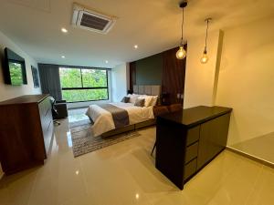 Un dormitorio con una cama y una ventana grande. en Rooca Urban, en Medellín