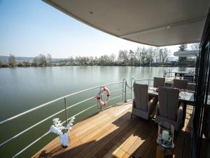 a boat with a table and chairs on the deck at Schönes Hausboot in Höxter in Höxter