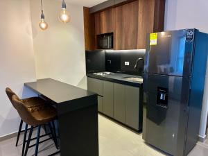 Una cocina con refrigerador, encimera y mesa. en Rooca Urban, en Medellín 36 fotos más