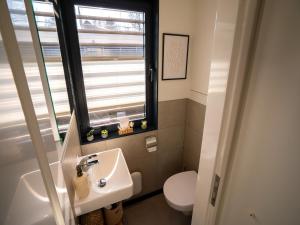 a bathroom with a sink and a toilet and a window at Schönes Hausboot in Höxter in Höxter