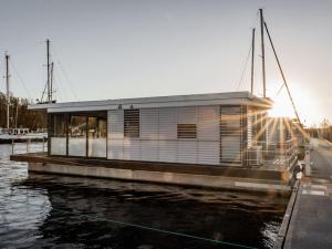 a houseboat is docked at a dock on the water at Peenemünde Resort in Peenemünde