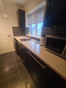 een keuken met een spoelbak en een magnetron bij Coastal town properties in Jarrow +16 foto's