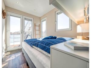 een slaapkamer met een bed, een bureau en ramen bij Bright Base with Coastal Access in Ribnitz-Damgarten