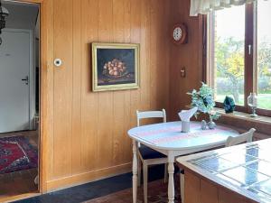 een keuken met een tafel en een foto van fruit aan de muur bij 4 star holiday home in VISBY in Visby +36 foto's