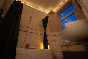a bathroom with a toilet and a window with lights at Apartment Lebenslang - Nähe Weserstadion & Viertel in Bremen