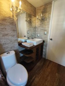 Un baño con inodoro, lavabo y espejo. en Céntrica habitación con vistas Larcomar, en Lima