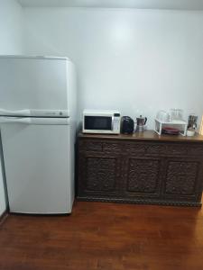 Una cocina con un refrigerador blanco y un microondas. en Céntrica habitación con vistas Larcomar, en Lima 5 fotos más