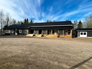 a building with a black roof and a dirt road at Vaaranhuoneistot in Syöte