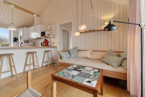 a living room with a couch and a table at Snug In Snogebæk A Modern Cozy Summer House in Neksø