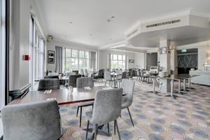 een eetkamer met een tafel en stoelen bij Sunday London Staines-upon-Thames Heathrow T5 in Staines