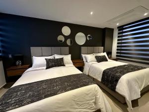 1 dormitorio con 2 camas y 2 espejos en la pared en Rooca Urban, en Medellín