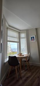 a table and chairs in a room with a window at Turtle Cove in Portrush