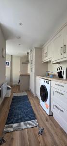 a kitchen with a washing machine in the middle at Turtle Cove in Portrush +4 photos