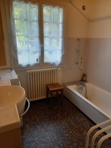 ein Badezimmer mit Badewanne und Fenster in der Unterkunft Gite la fougère vue sur la campagne in Verrières-en-Forez