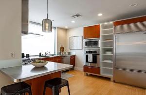 een keuken met een roestvrijstalen koelkast en een aanrecht bij Calm Modern Retreat in the Heart of Salt Lake City in American Towers Condominium