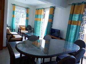 a living room with a glass table and chairs at Rayon Bleu A3 two bedroom apartment-perfect sea escape! in Flic-en-Flac