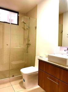 a bathroom with a shower and a toilet and a sink at Habitación en Quito in Quito