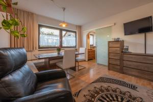 Una sala de estar con un sofá de cuero y una mesa. en App Brunner, en Valdaora